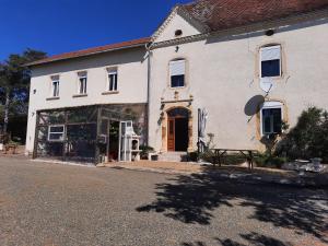 a white house with a bench in front of it at Maison Hormidas in Crouseilles