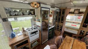 斯卡布羅的住宿－2 x Double Bed Glamping Wagon at Dalby Forest，厨房配有炉灶和餐桌。