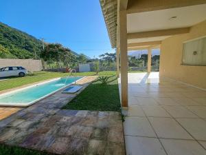 une maison avec une piscine dans une cour dans l'établissement Casa de campo Ar piscina Churrasqueira Saquarema, à Jaconé