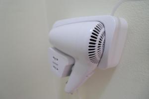 a white hair dryer hanging on a wall at Casa Blanca Rooms in Himare
