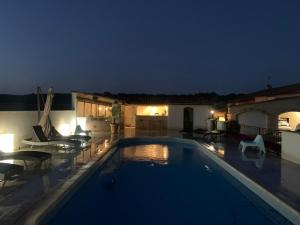 a swimming pool in a yard at night at Les Gîtes de La Petite Campagne in Mane