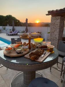 een tafel met eten op een patio bij Les Gîtes de La Petite Campagne in Mane