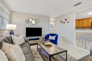 a living room with a couch and a tv at Little Beach House w/ POOL&SPA - 5 minutes to Vanderbilt Beach (Pet Friendly) in Naples