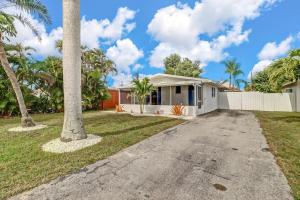 a house with a palm tree and a driveway at Little Beach House w/ POOL&SPA - 5 minutes to Vanderbilt Beach (Pet Friendly) in Naples