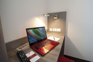 un computer portatile seduto su un tavolo accanto a un telecomando di Amaro Hotel a Bergkirchen
