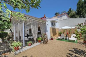 a patio of a house with white furniture and plants at Vasia's Small Villa in Skopelos Town