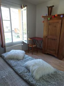 2 cuscini bianchi su un letto in una camera con finestra di Chambre d'hôte chez Florence a Vourles
