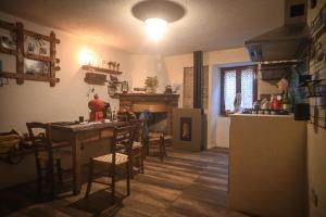 uma cozinha e sala de jantar com uma mesa e um frigorífico em Casetta Nonna Augusta (Spello 9 km-Assisi 12 km) em Spello
