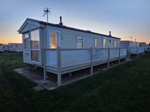 a tiny house on a trailer in a field at Esmeralda's Caravan Hire Mablethorpe in Mablethorpe