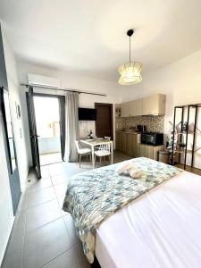a bedroom with a large bed and a kitchen at Brand new studio Sea View in Agia Pelagia