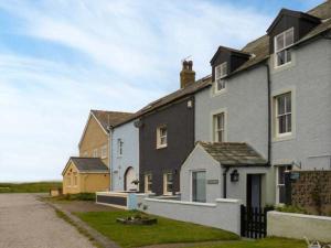a group of houses on a road next to a field at Gulls Hatch in Maryport