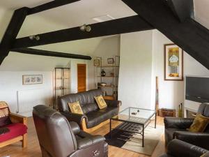 a living room with leather furniture and a tv at Gulls Hatch in Maryport
