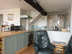 a kitchen with a counter and two chairs in it at Gulls Hatch in Maryport