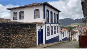 uma casa azul e branca com uma parede de pedra em A3EM Casa de Gorceix em Ouro Preto
