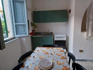 een keuken met een tafel met stoelen en een tafelkleed erop bij Casa di Lavanda in Saturnia