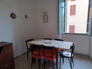 a table and chairs in a room with a window at Casa di Lavanda in Saturnia