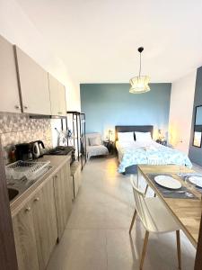 a kitchen and a bedroom with a bed and a table at Brand new studio Sea View in Agia Pelagia