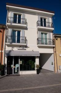 a white building with two balconies on top of it at CasaDodici Boutique Hotel in Cesenatico