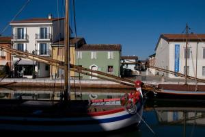 a boat sitting in the water next to a building at CasaDodici Boutique Hotel in Cesenatico