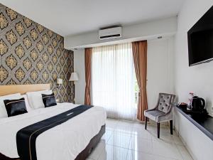 Habitación de hotel con cama y TV en Super OYO Collection O 92254 Hotel By Orchid en Duwet