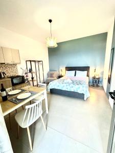 a bedroom with a bed and a table and a desk at Brand new studio Sea View in Agia Pelagia