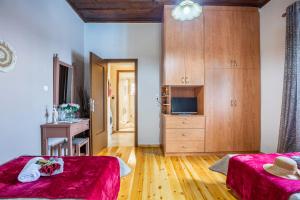 a large room with two beds and a television at The Morus House with Private pool in Melidhónion