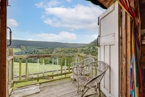 a balcony with two chairs and a view of a field at Glamping Wagon - 1 x Double Bed 2 x Single Bed in Scarborough