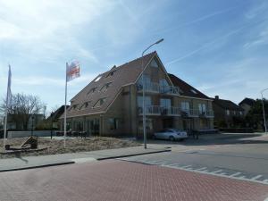 a building with a flag on the side of a street at Hotel het Zwaantje in Callantsoog