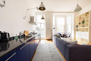 a kitchen with blue cabinets and a blue couch at Stylish & Spacious Notting Hill Loft in London