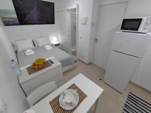 a small white bedroom with a bed and a refrigerator at Room Dream Beato in Lisbon