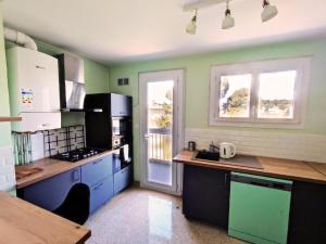 a kitchen with blue and green walls at Grand Appartement Ensoleillé avec Parking in Nîmes