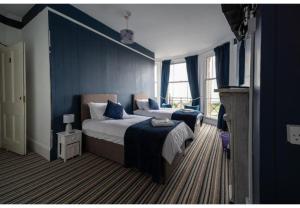 a blue bedroom with a bed and a television at OYO Lord Kitcheners Guest House in Lowestoft