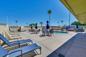 eine Terrasse mit Stühlen, Tischen und einem Pool in der Unterkunft Pet-Friendly Yuma Vacation Rental with Pool Access! in Yuma