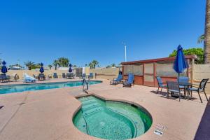 a swimming pool with chairs and a table and umbrella at Pet-Friendly Yuma Vacation Rental with Pool Access! in Yuma