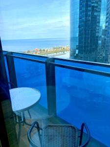 a balcony with a chair and a view of the ocean at ORBI CITY lux studio apartment in Batumi