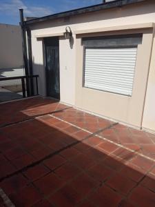 a house with a tiled patio with a garage at Monoambiente con terraza cerca de todo in Corrientes