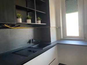 - une cuisine avec un évier et un comptoir noir dans l'établissement Skyline, à Novara