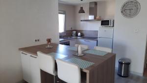 eine Küche mit einem Tisch und Stühlen sowie einem Kühlschrank in der Unterkunft Pin-Rolland - appartement 2 chambres à 400m de la plage in Saint-Mandrier-sur-Mer