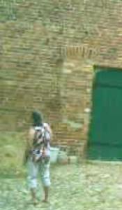 a person walking in front of a brick wall at Bauernhof-Streichel-Zoo-&-Reiter-Suite in Gulow