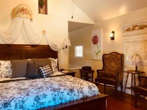 ユーレカ・スプリングスにあるRock Cottage Gardens B&Bのベッドルーム1室(ベッド1台、椅子付)