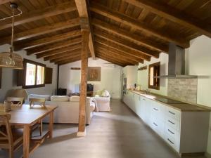 cocina abierta y sala de estar con techos de madera. en Casa rural en jerte: La casa del molino en Jerte