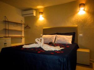 Un dormitorio con una cama con dos cisnes. en Villa Giulia Morro Residence, en Morro de São Paulo