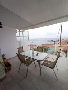 a table and chairs on a patio with a view of the ocean at Vaggelitsa's House in Pythagoreio