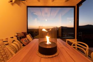 a candle sitting on a table in front of a window at Villa Calderón Hondo. Top design , views and pool Lajares-Corralejo in Corralejo