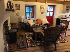 sala de estar con sofá y mesa en Sweet Meadow A delightful romantic thatched cottage by river Shannon on 4 acres is for peace party family or work from home, en Rooskey