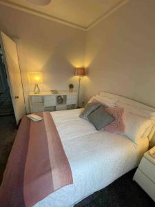 um quarto com uma grande cama branca e 2 almofadas em Wellington Retreat em Montrose