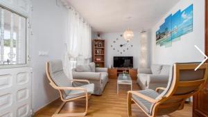 a living room with a couch and chairs and a tv at El-Cason 1 in Almuñécar