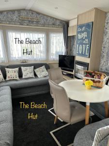 a living room with a couch and a table at Lyons Robin Hood, RHYL "The Beach Hut" in Rhyl