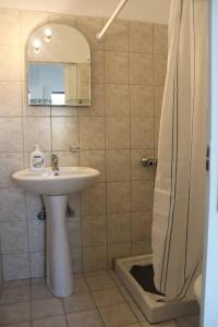 een badkamer met een wastafel en een douche met een spiegel bij Sunset State Of Mind 1 in Néa Thésis