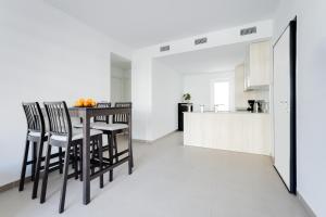 eine Küche und ein Esszimmer mit Tisch und Stühlen in der Unterkunft Apartment Arenales Playa del Sol in Arenales del Sol